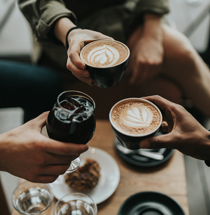 Friends together at coffee shop toasting with drinks.