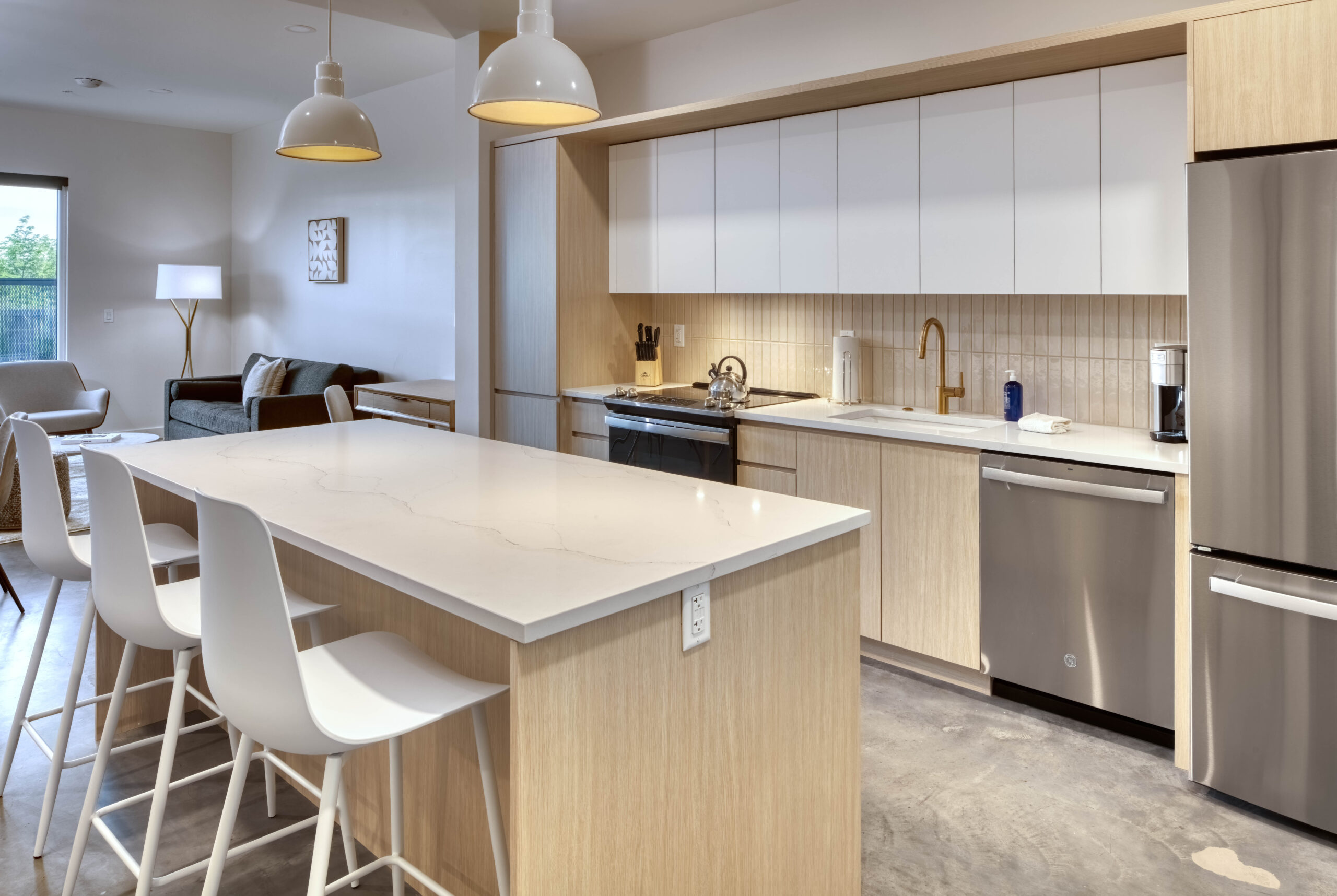 a light colored bar countertop with seating and overhead lights