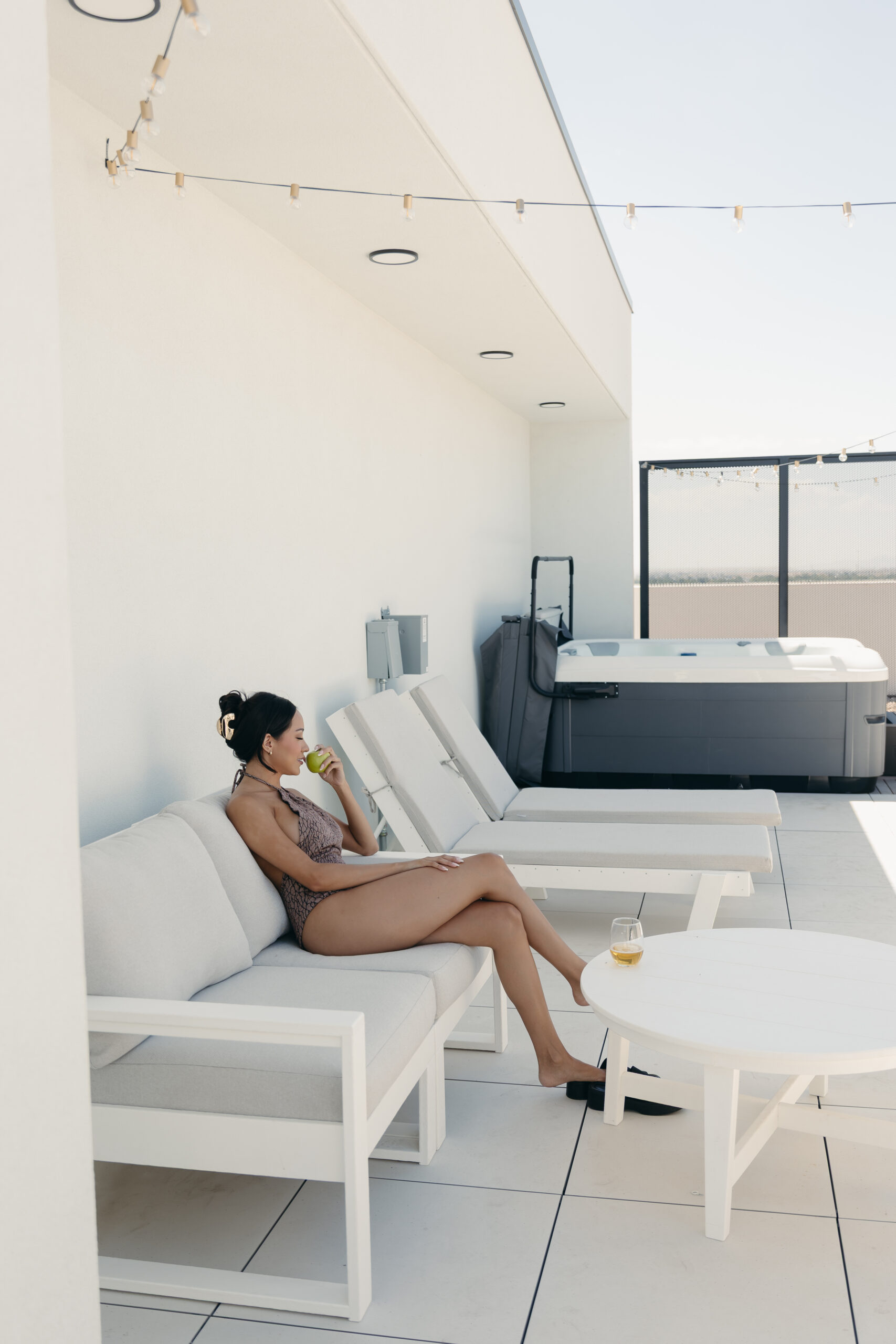 Woman on private balcony with hot tub in luxury apartment in SLC.
