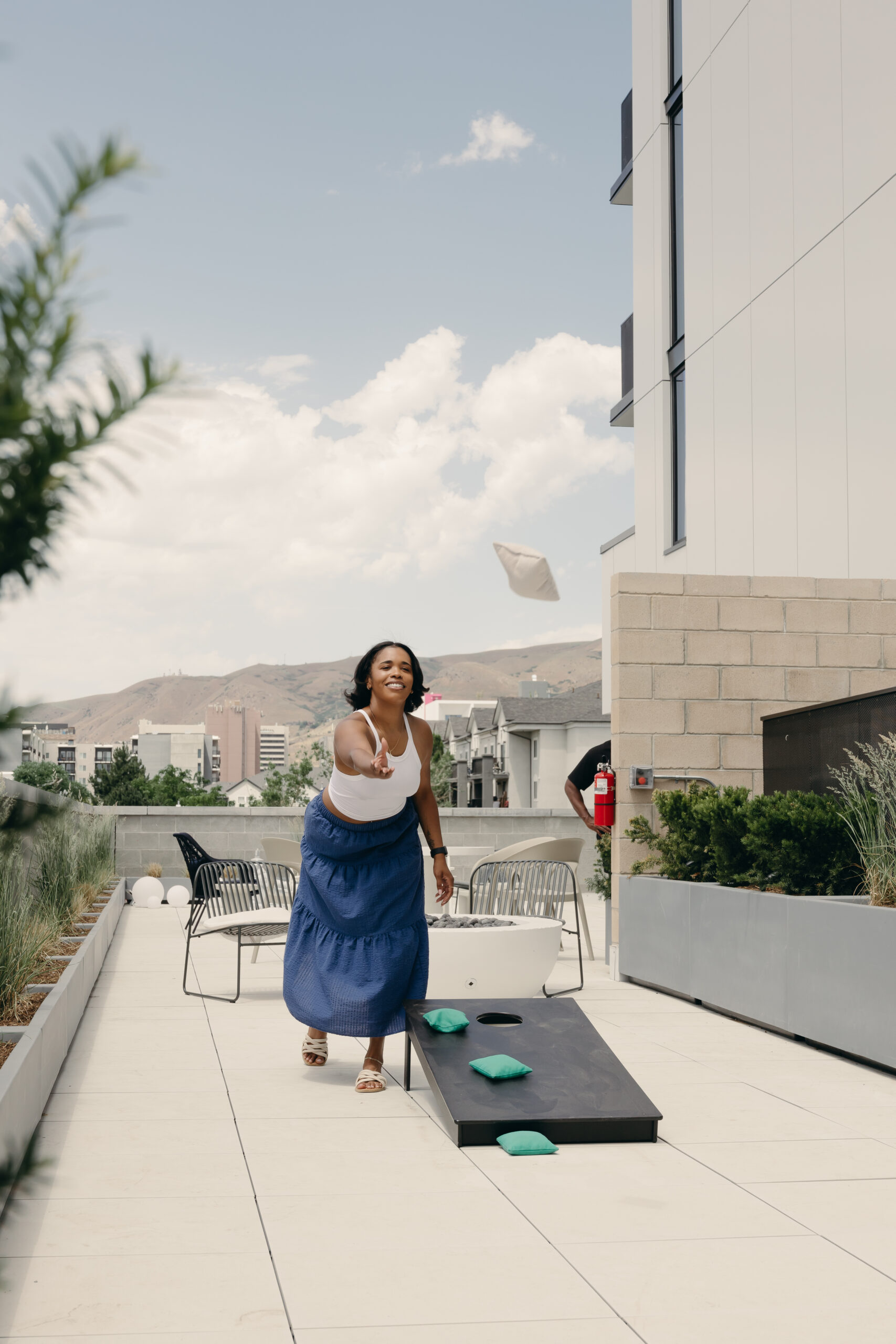 Woman playing cornhole on terrace in downtown SLC