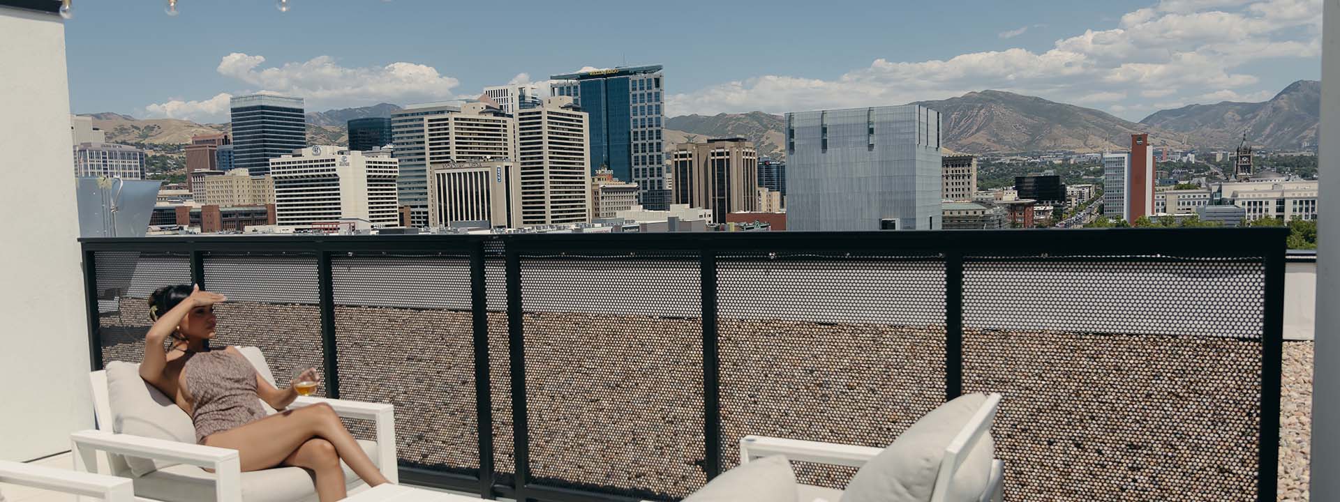 Person in swim suit sitting in lounge chair on rooftop deck at Brix.