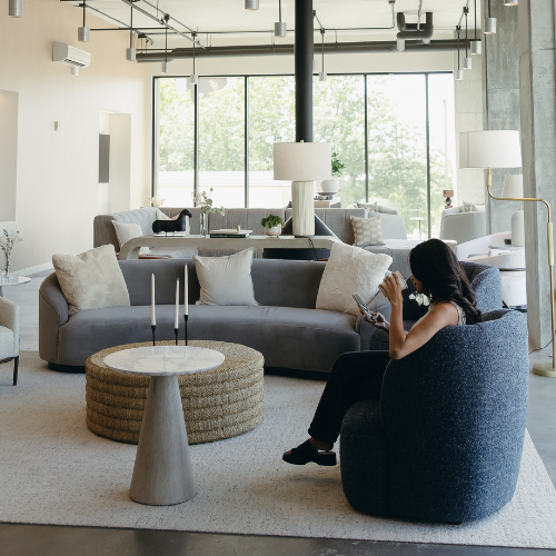 Woman reading in community lounge at Brix Residences in SLC.