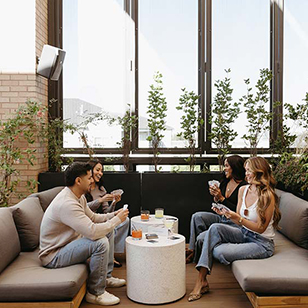 Friends playing games together with cocktails on rooftop deck.